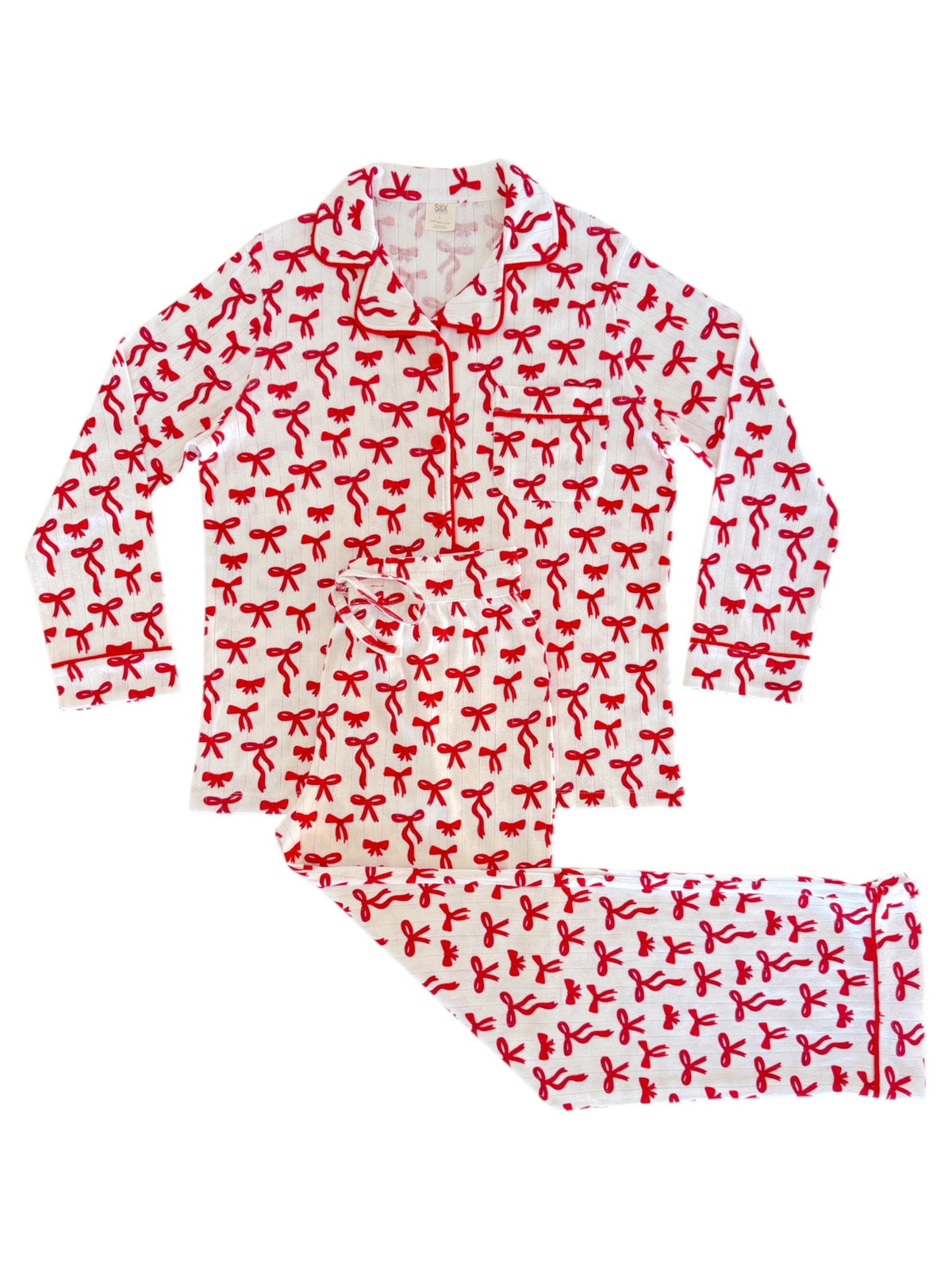 Red and white pajama set featuring a festive bow pattern, including a long-sleeve top and matching pants.
