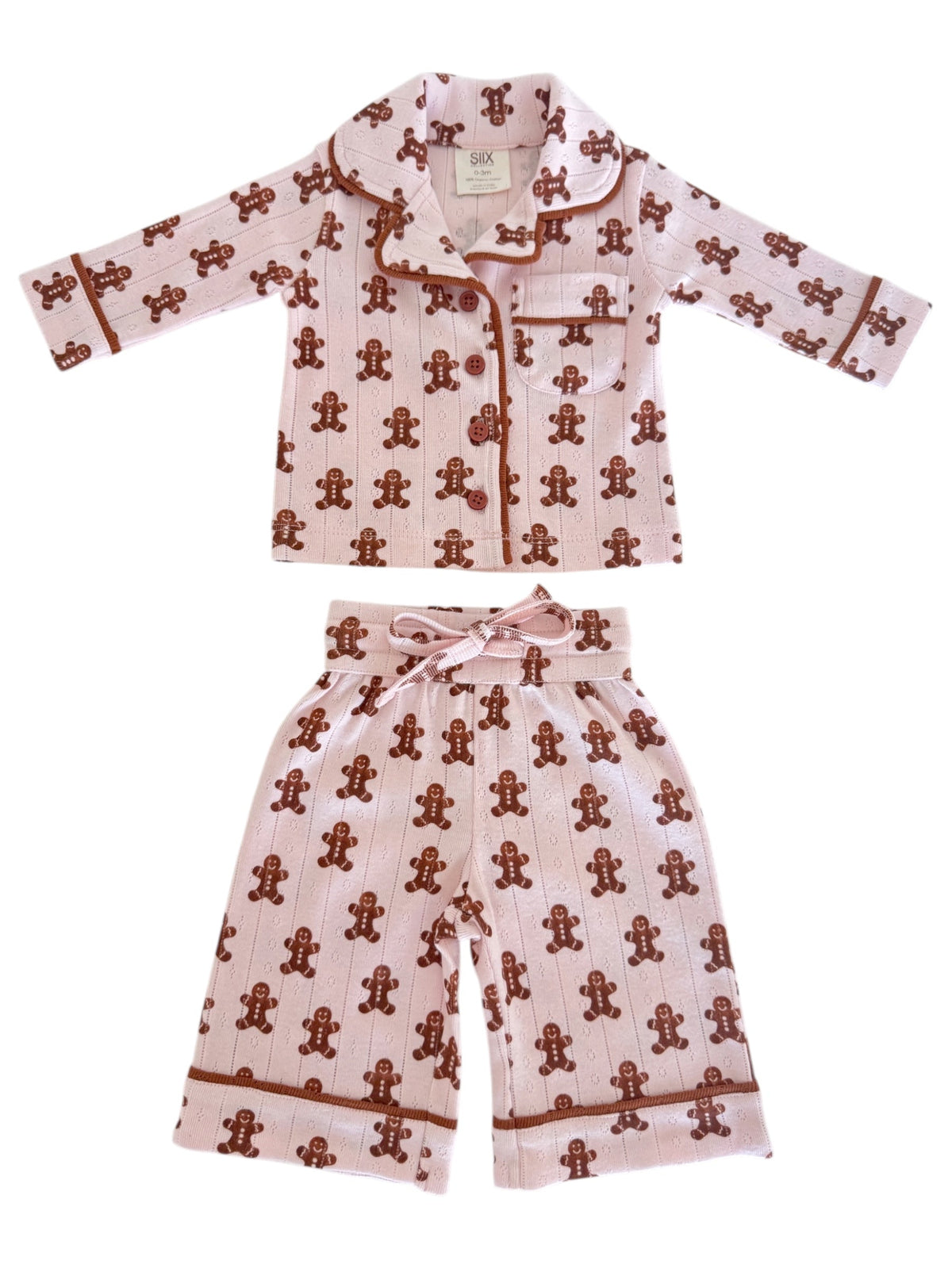Pink children's pajama set featuring a gingerbread man pattern on both the top and pants.