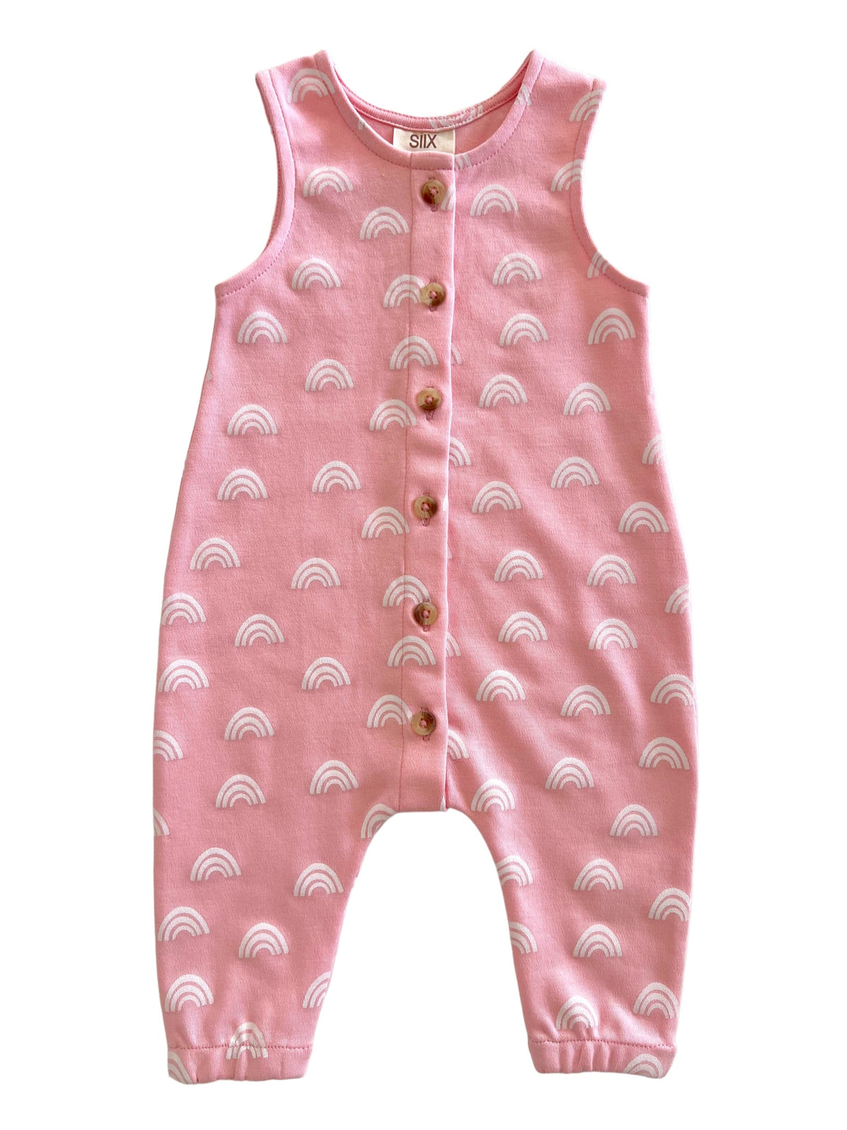 Pink children's romper featuring white rainbow patterns and wooden buttons down the front.
