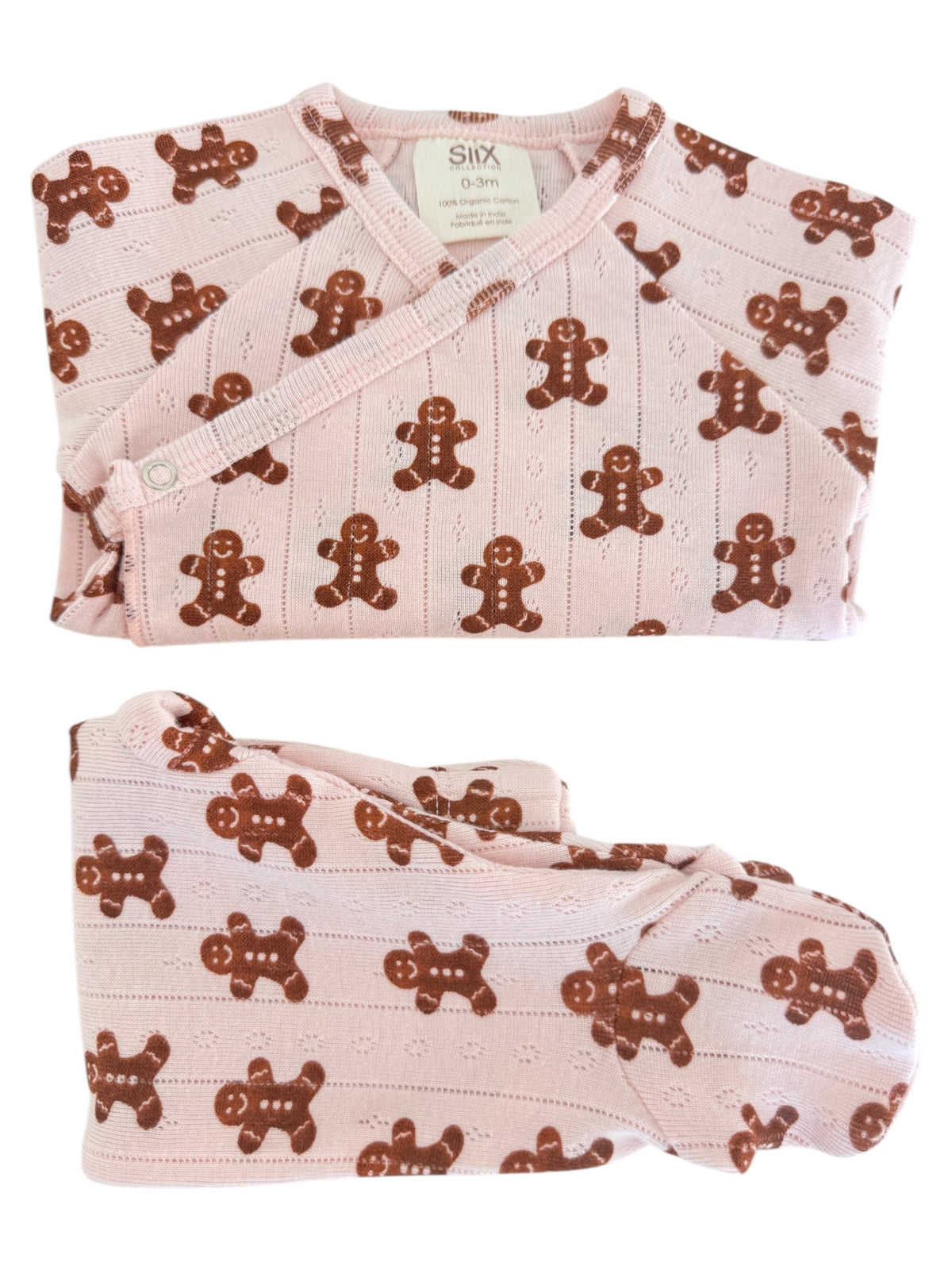 Pink baby outfit with gingerbread man pattern, including a wrap top and pants, made from 100% organic cotton.