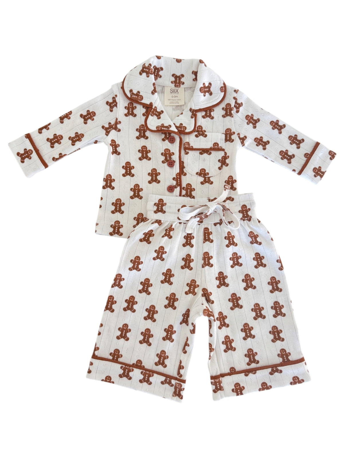 White pajama set with gingerbread man pattern, featuring long sleeves and pants, ideal for cozy nights.