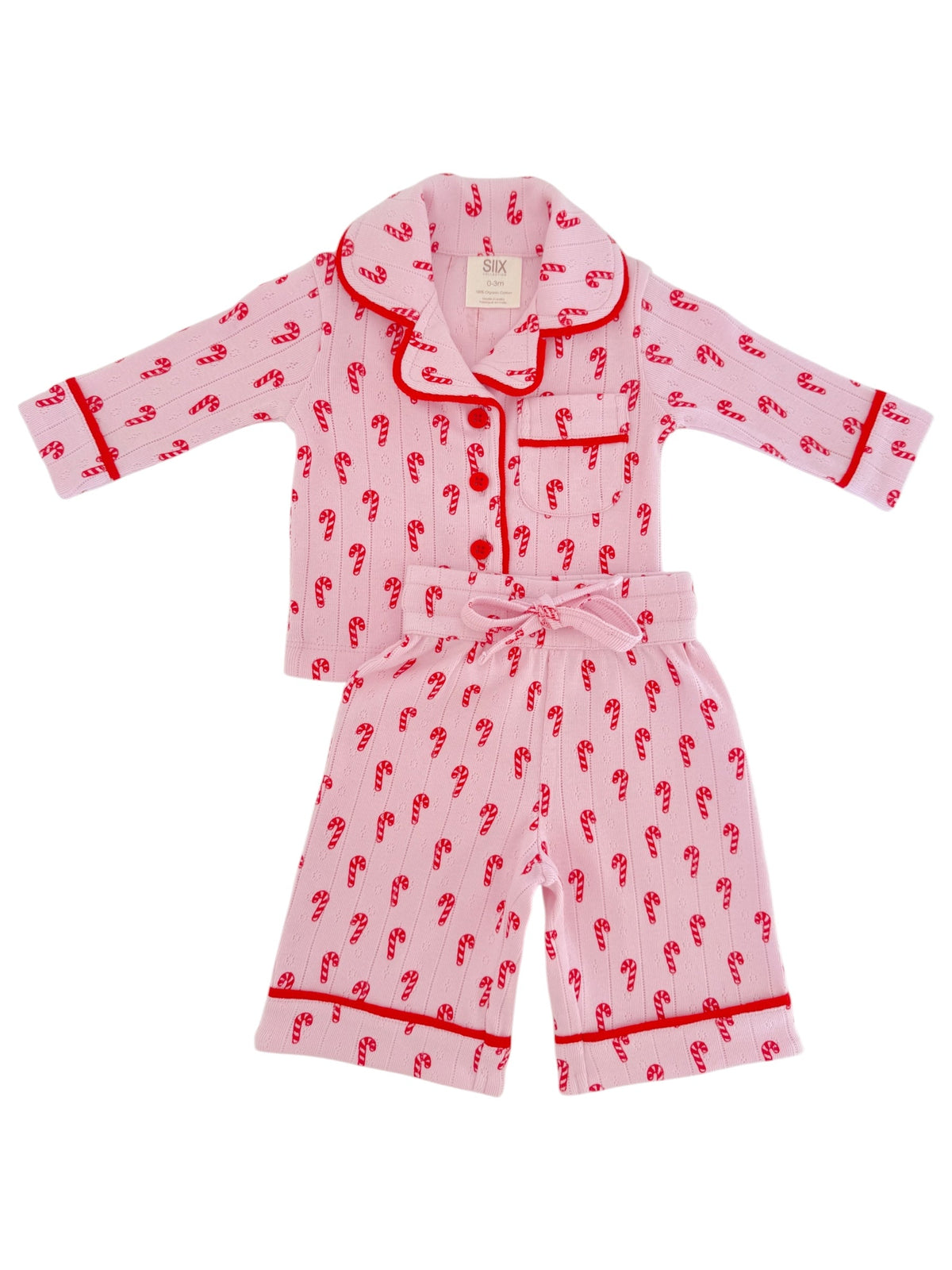 Pink pajama set with red candy cane pattern and trim, featuring a collared top and elastic waist shorts.