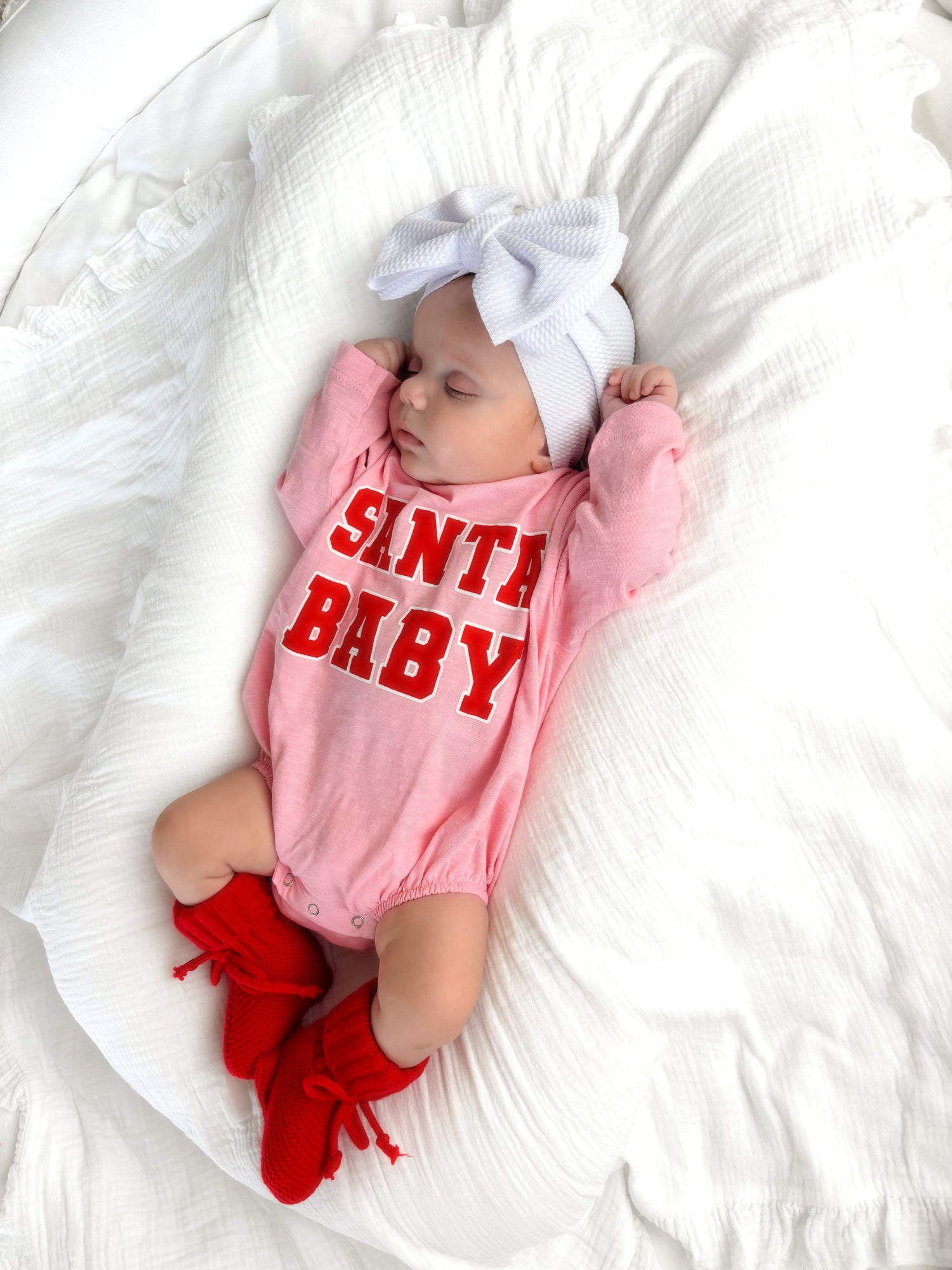 Sleeping baby in pink onesie with