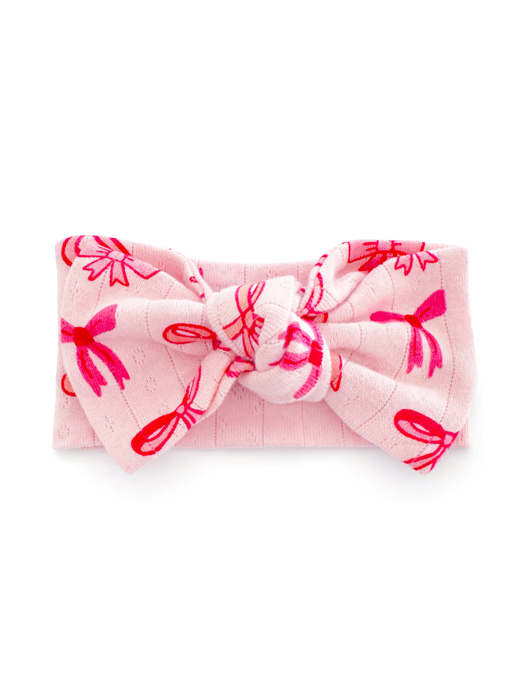 Pink headband with red bow and ribbon print, featuring a knot at the center. Ideal for infants or toddlers.