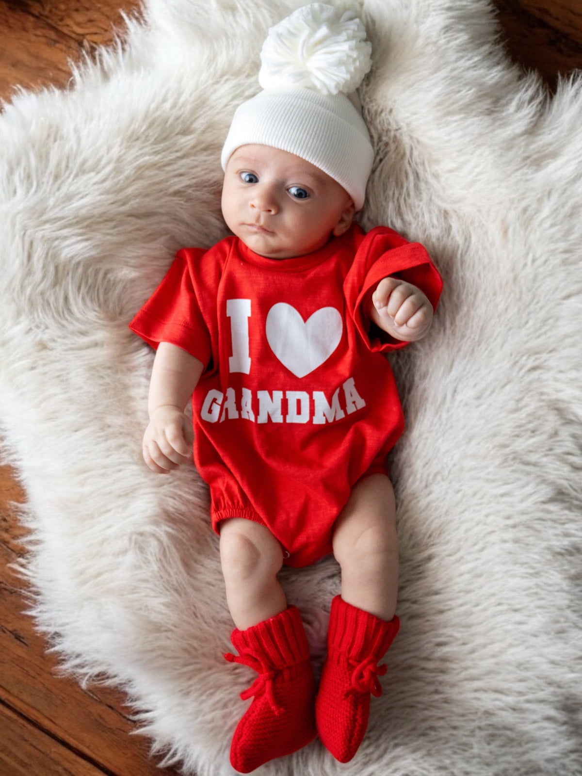 Baby in a red onesie reading