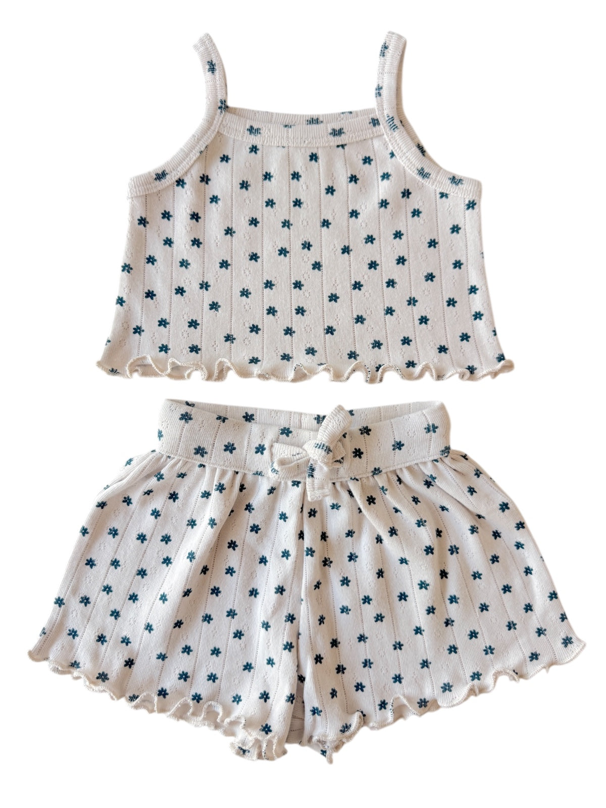 Lightly patterned two-piece outfit featuring a cropped top and matching shorts with a ruffled hem.