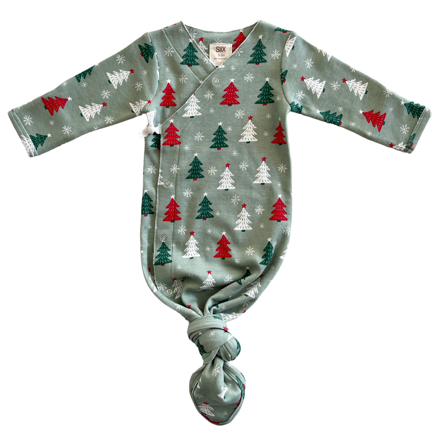 Green baby swaddle with red and white Christmas trees and snowflakes, featuring long sleeves and a knotted bottom.