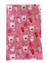 Pink fabric with cheerful reindeer faces and colorful mittens, accented by snowflakes and leaves. Perfect for winter themes.