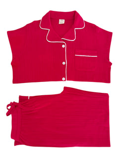 Pink pajama set featuring a short-sleeve top with buttons and a matching tie-waist skirt.