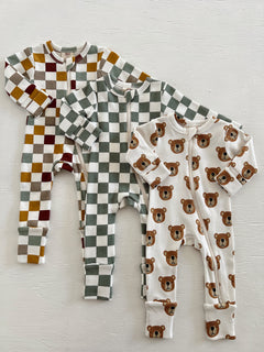 Three baby onesies: two have checkered patterns, and one features a bear print on a white background.