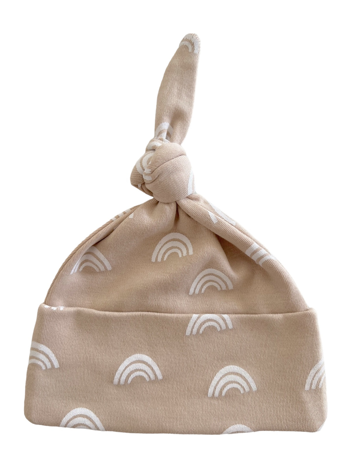 Beige baby hat with white rainbow patterns and a knot at the top.