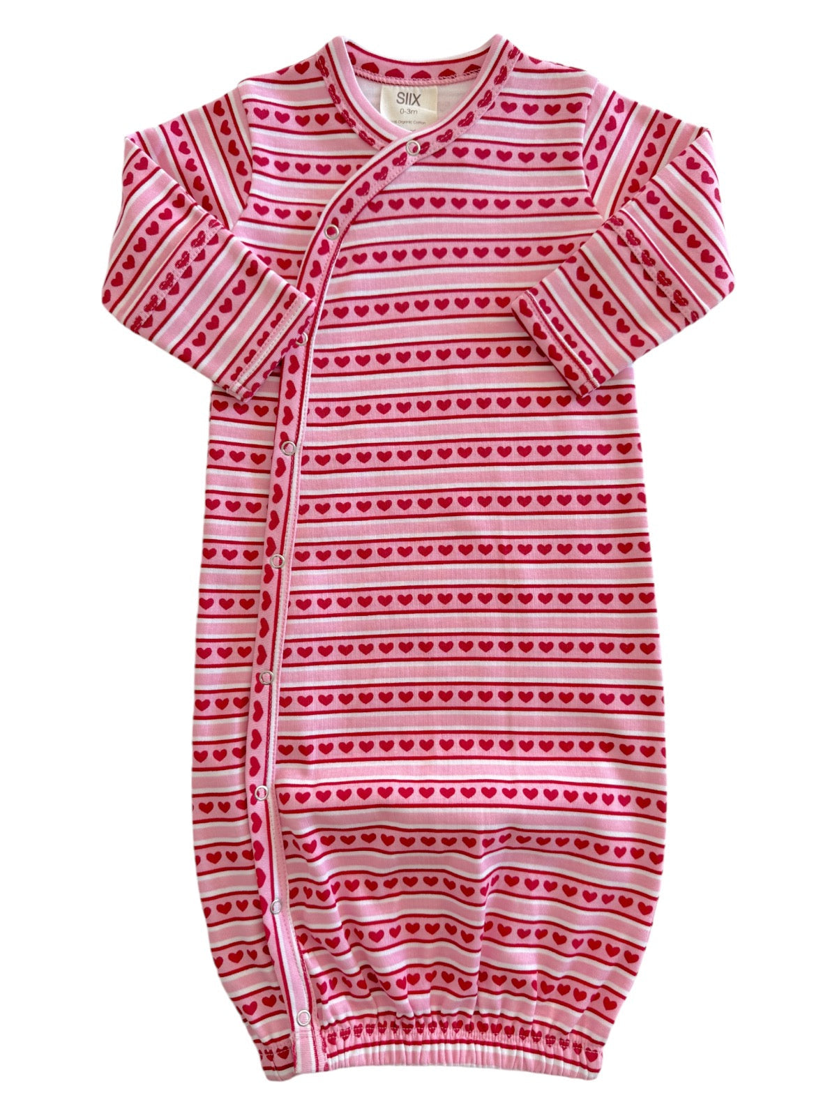Pink infant sleeper with heart patterns and striped design, featuring long sleeves and snap button closures.