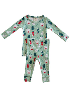 Green pajama set with festive reindeer and stockings design on top and matching pants.