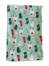 Festive fabric featuring reindeer, mittens, and stockings on a light green background with snowflakes.