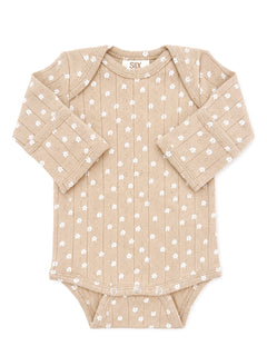 Tan baby bodysuit with white floral pattern and long sleeves, featuring snap closures at the bottom.