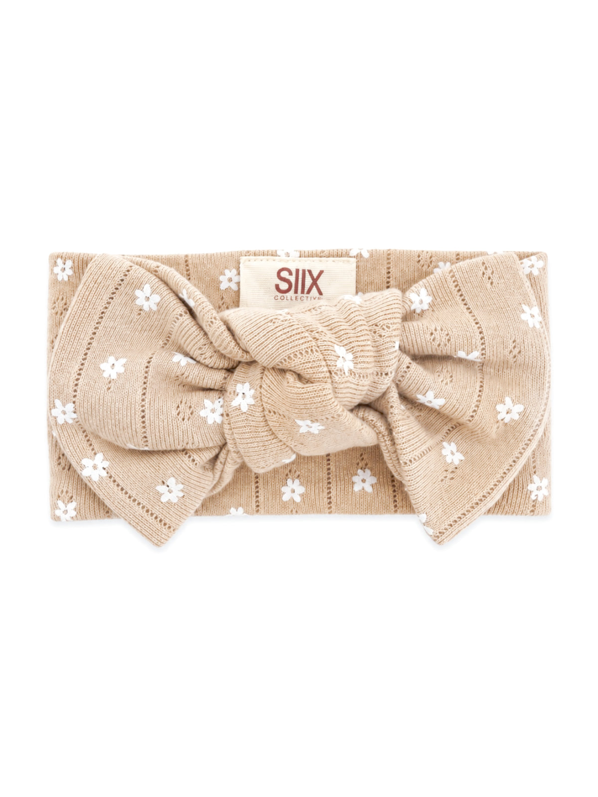 Beige headband with white floral patterns and a large bow, labeled 