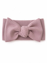 Light pink ribbed headband with a large bow detail, displayed on a white background.