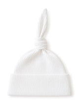 White ribbed hat with a knotted top, designed for a stylish and cozy look.