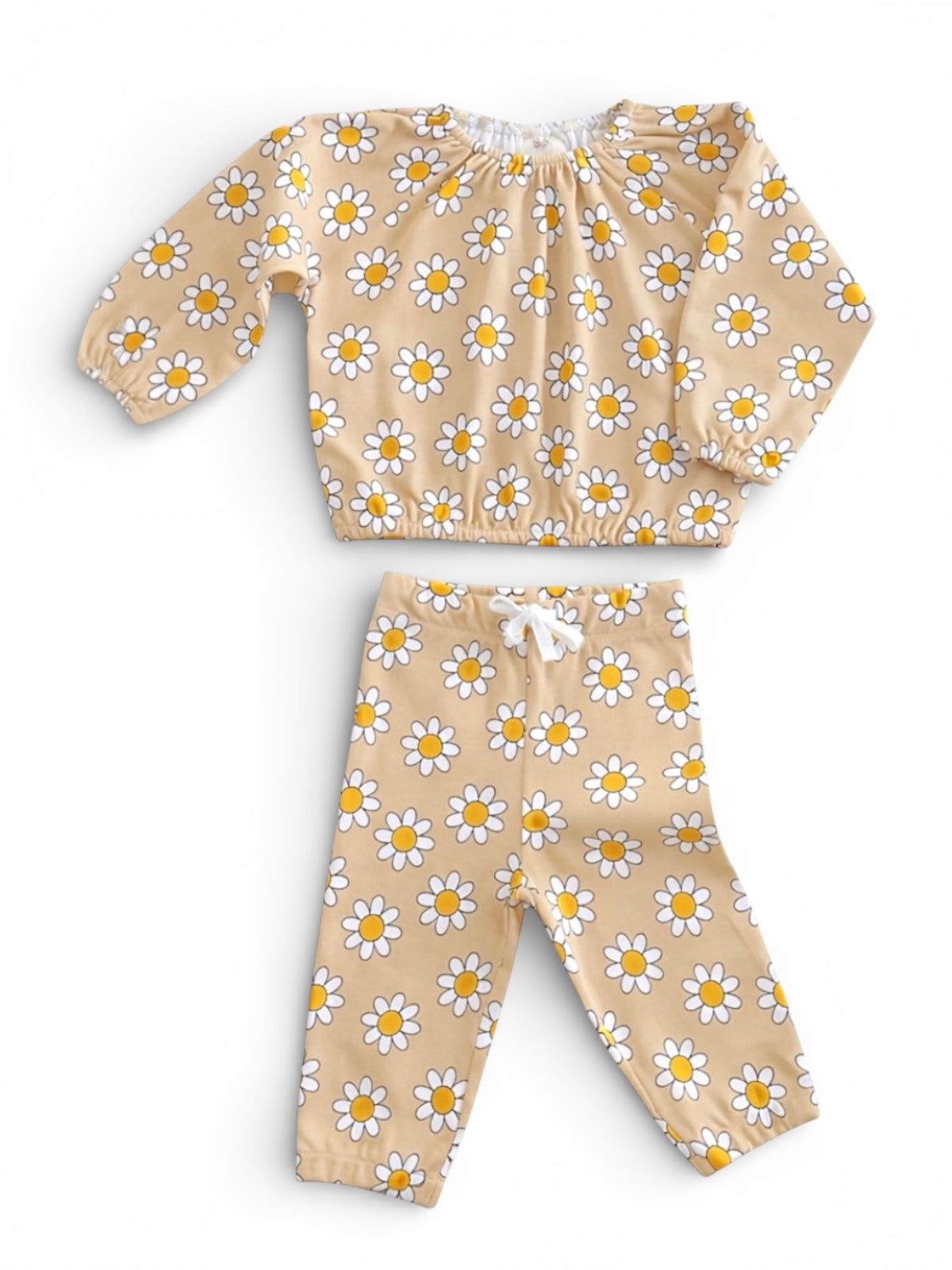 Brown outfit with white and yellow daisies, featuring a long-sleeve top and matching pants. Perfect for kids.