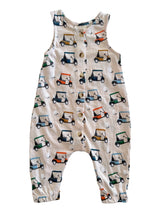 Tan romper with a golf cart print and buttons, perfect for young children. Great for casual outings or playtime.