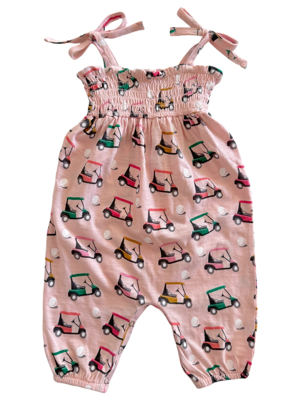 Pink jumpsuit with golf cart pattern and tie straps, perfect for casual outdoor play.