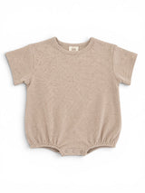Light beige baby onesie with short sleeves and snap closures at the bottom, featuring a textured fabric.