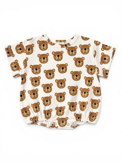 Short-sleeve baby shirt featuring a playful bear face pattern on a cream background.