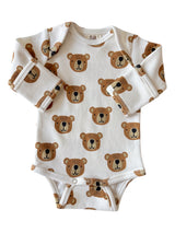 Long-sleeve baby bodysuit with a cute bear print in shades of brown on a light background.