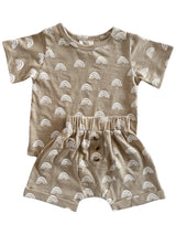 Beige toddler outfit with white rainbow patterns, featuring a short-sleeved top and matching shorts with buttons.