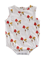 White baby romper with colorful mushroom print in red, yellow, and brown tones.