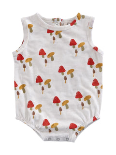 White baby romper with colorful mushroom print in red, yellow, and brown tones.