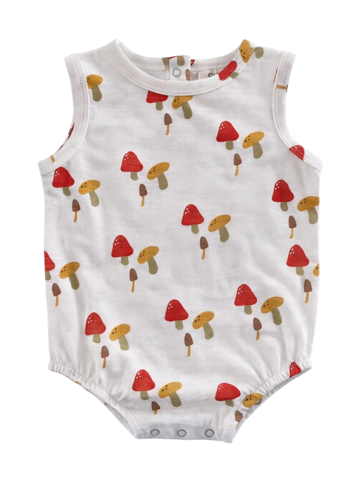 White baby romper with colorful mushroom print in red, yellow, and brown tones.