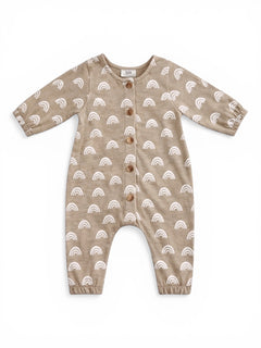 Tan baby romper with white rainbow patterns and wooden buttons, featuring long sleeves and elastic ankle cuffs.