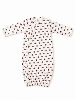 White baby gown with football pattern, featuring long sleeves and snap closures along the side.