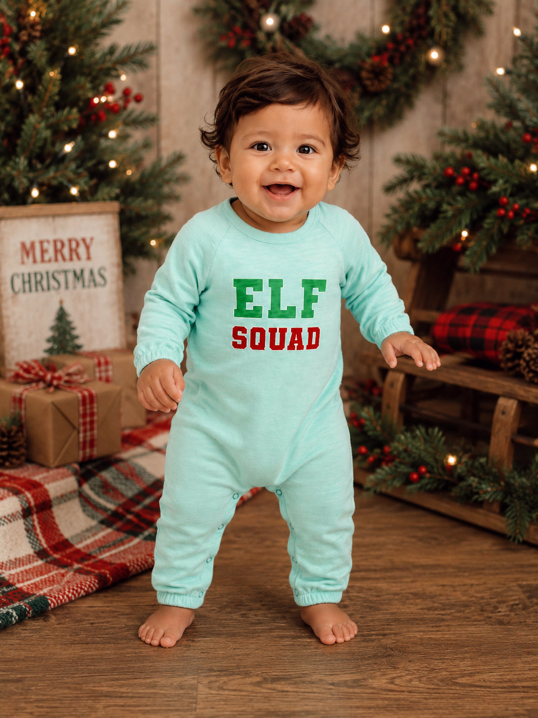 Smiling baby in a light blue onesie with 