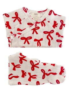 White infant outfit with red bow patterns, including a top and matching footie, made from 100% organic cotton.