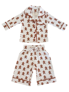 Gingerbread-themed children's pajama set with a collared top and shorts, featuring playful patterns.