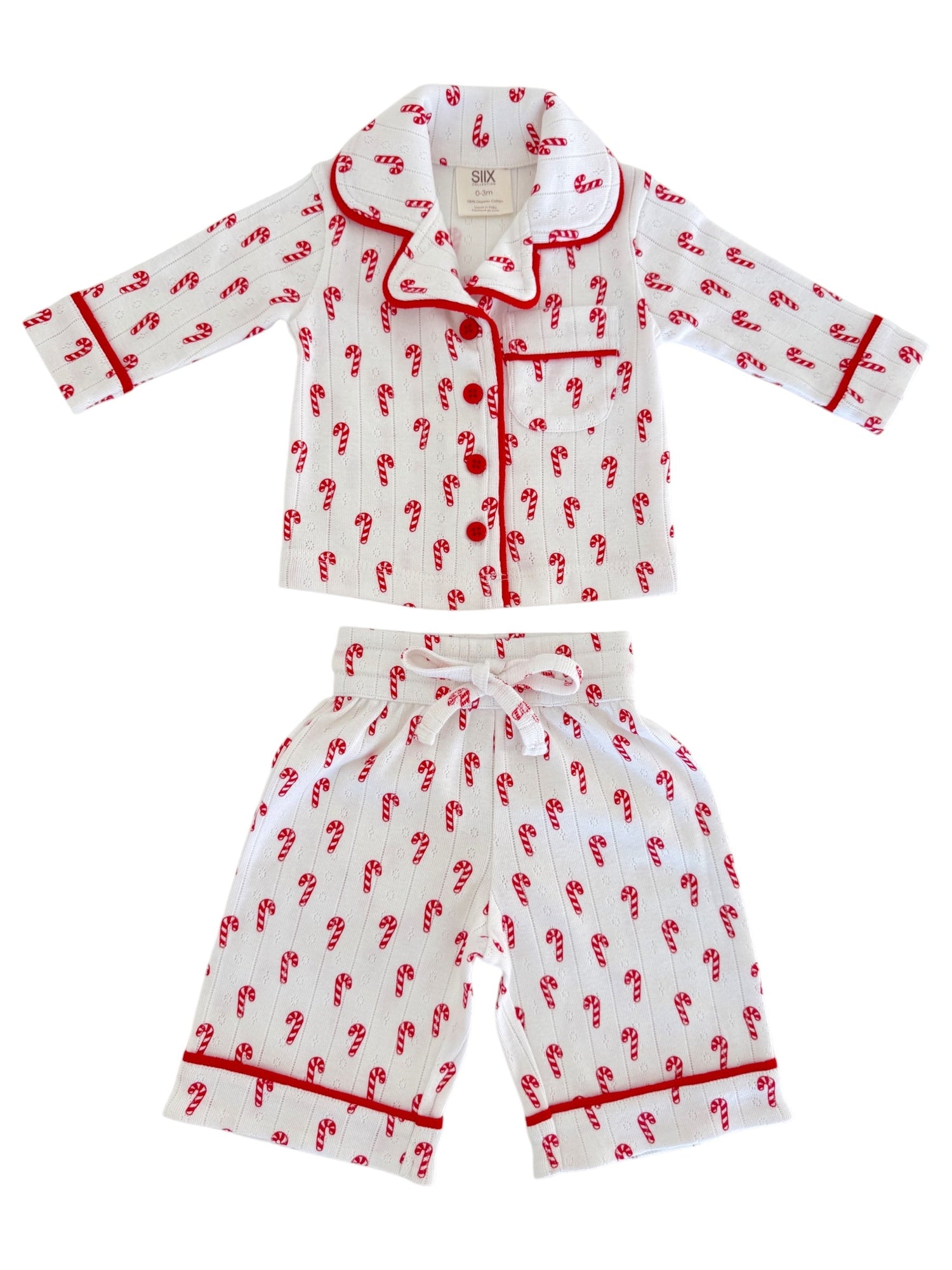 Children's pajamas with red candy cane pattern on white fabric, featuring a collared shirt and matching pants.