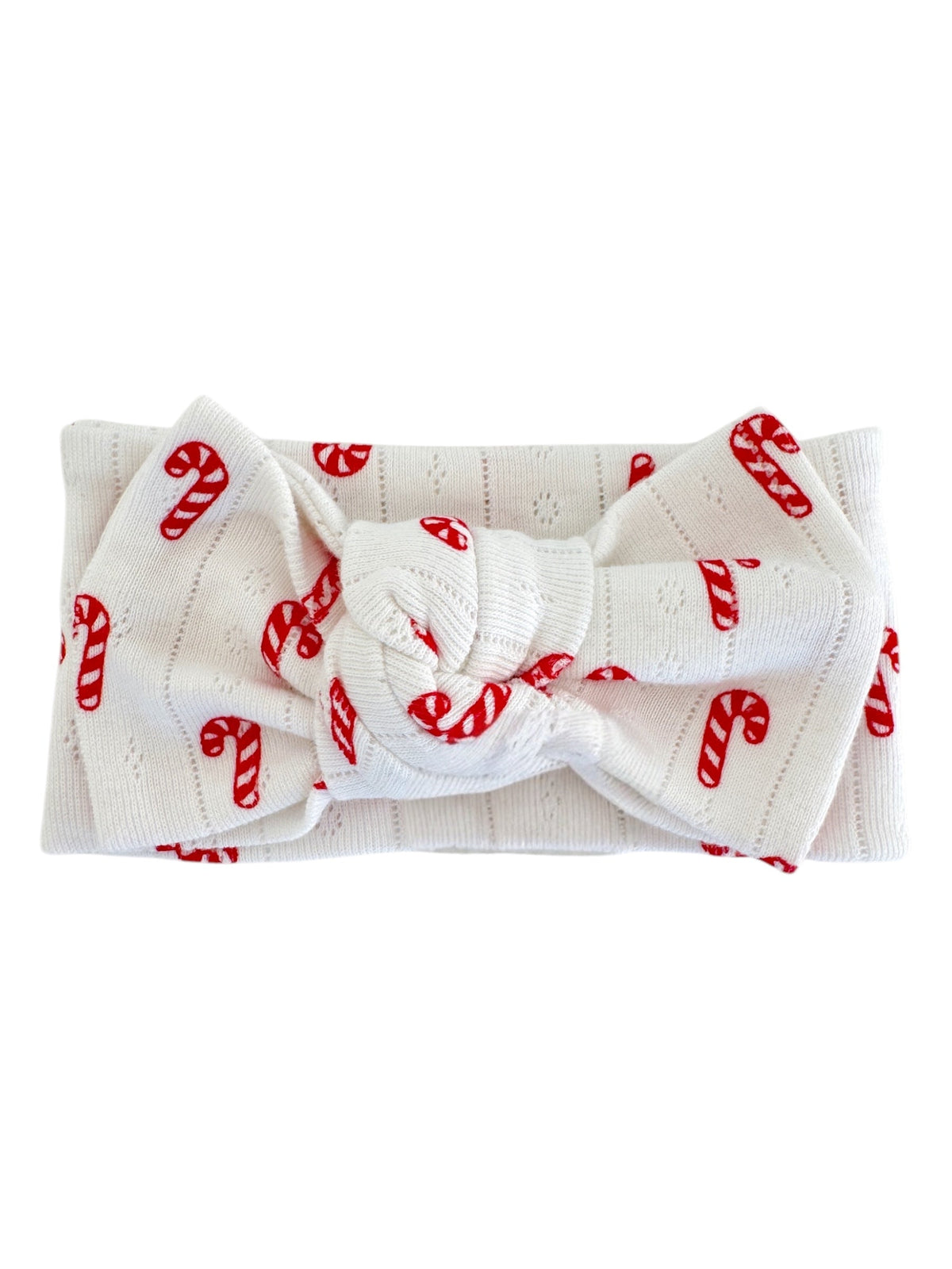White headband with red candy cane pattern, featuring a knotted bow in the center.