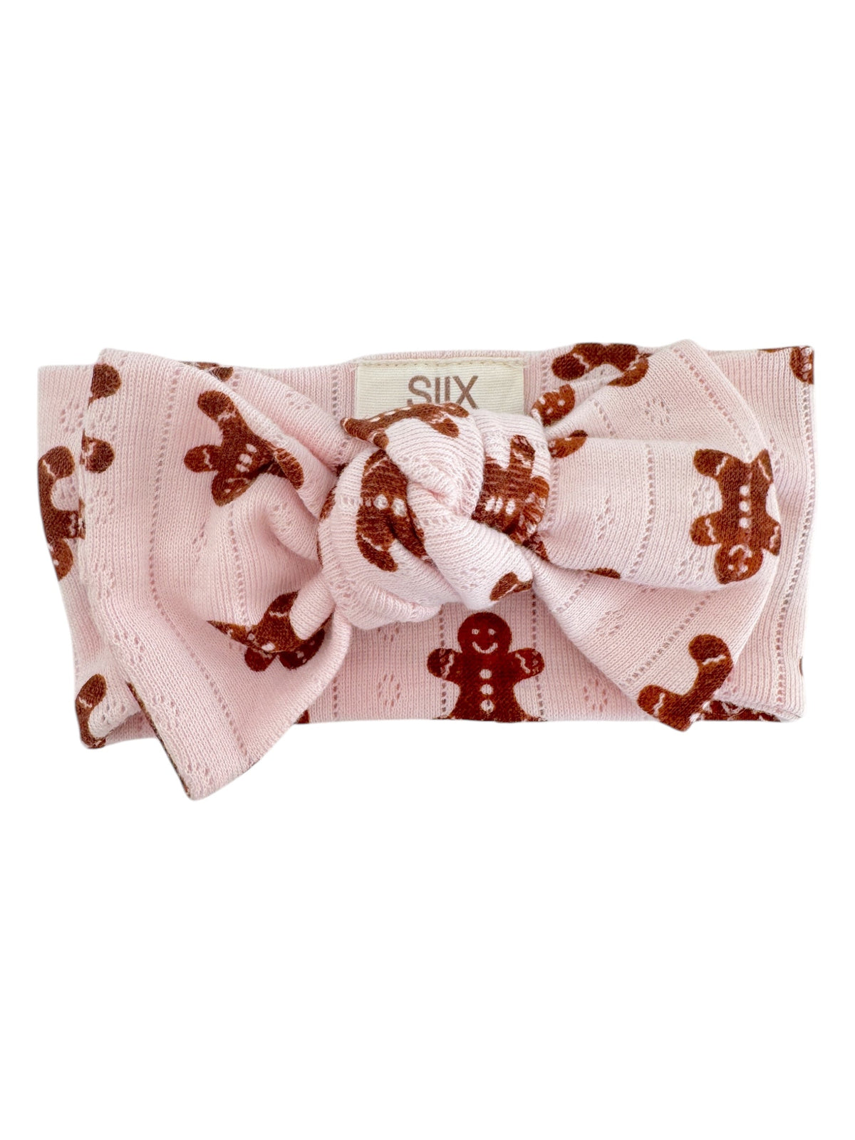 Pink headband with a large knot and gingerbread man pattern, perfect for festive occasions.