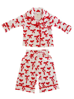 Children's pajama set featuring a white fabric adorned with red bow patterns. Soft and cozy design for bedtime.