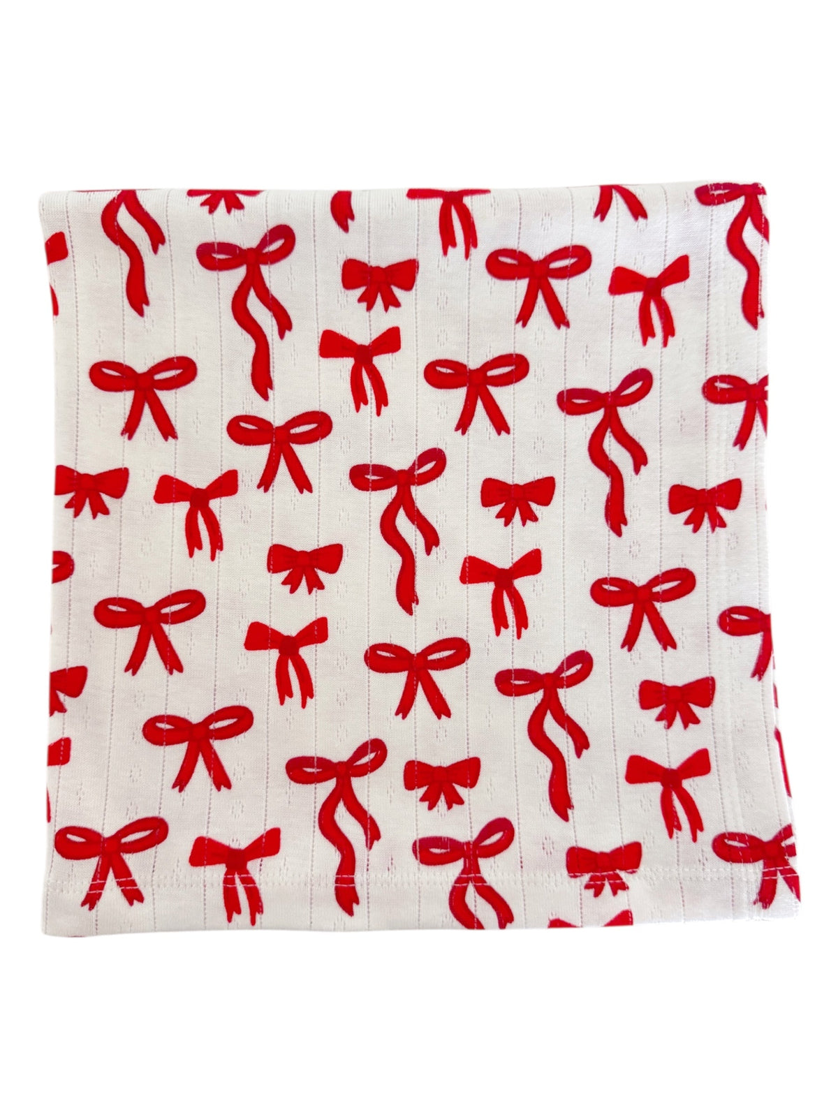 White fabric with a repeating pattern of red bows.