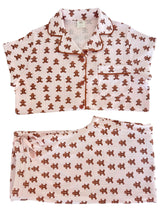 Pink pajama set featuring a gingerbread man pattern, includes a short-sleeve top and matching pants.