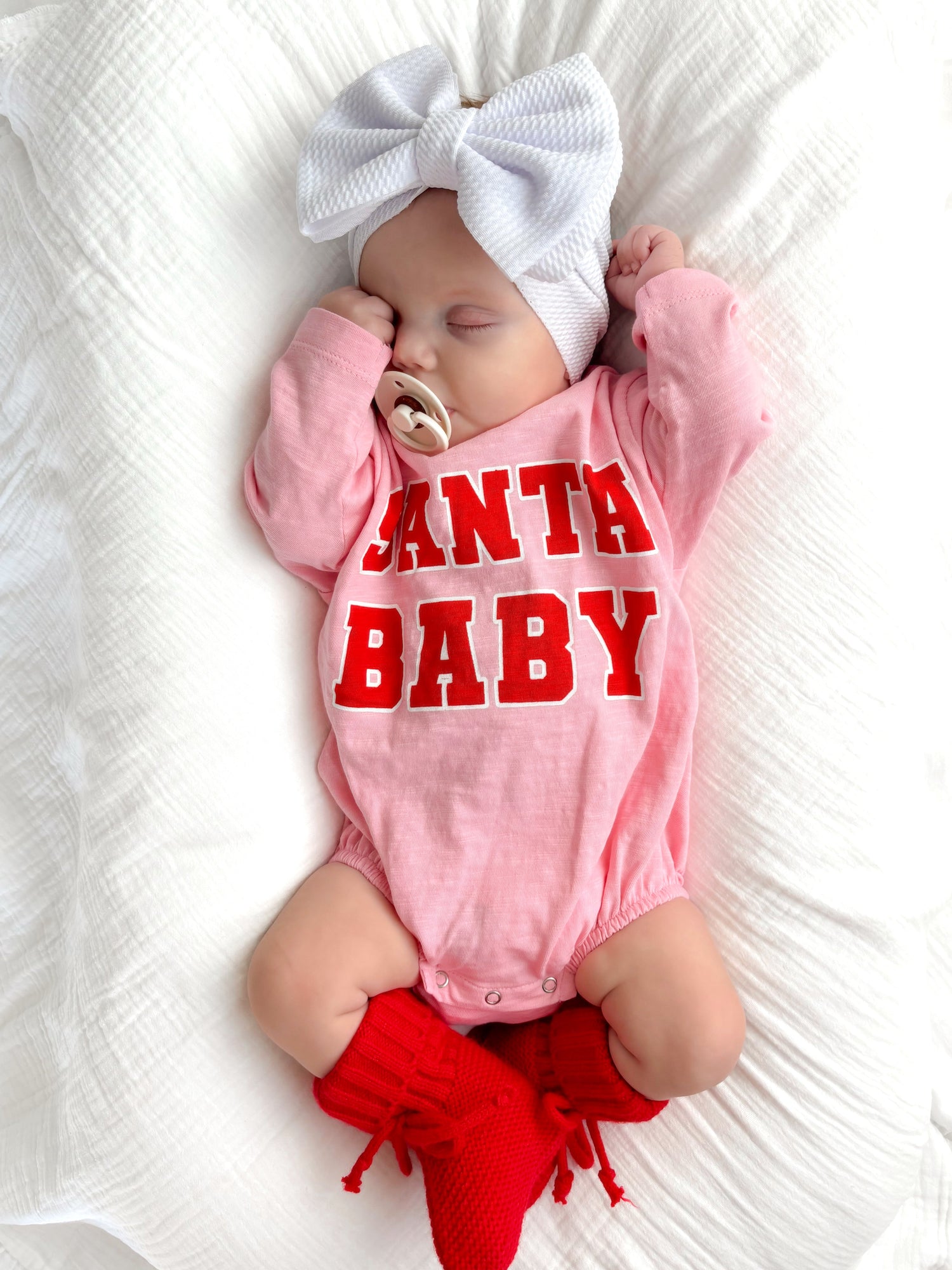 Sleeping baby in pink onesie with 