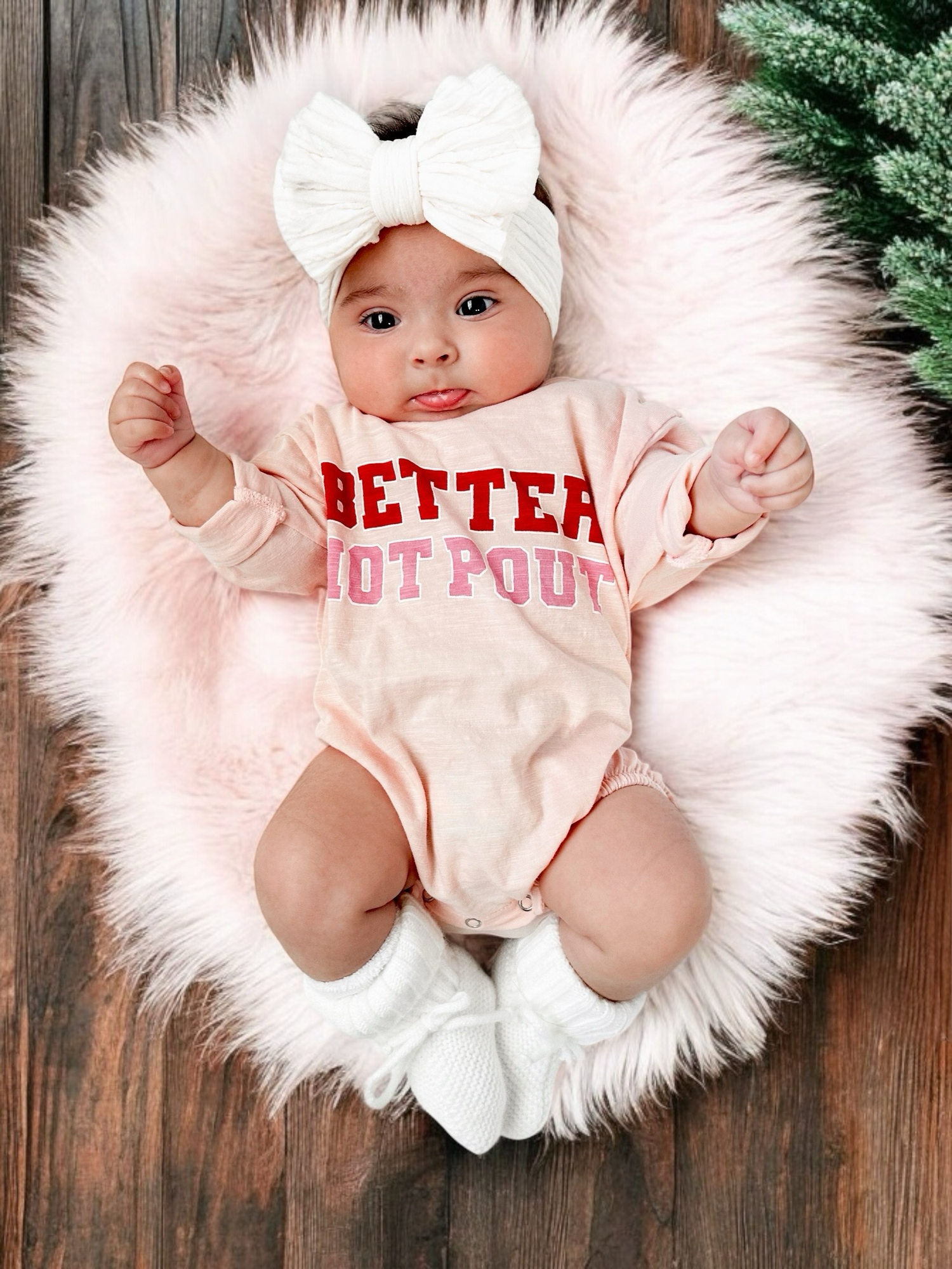 Baby in a pink onesie with 