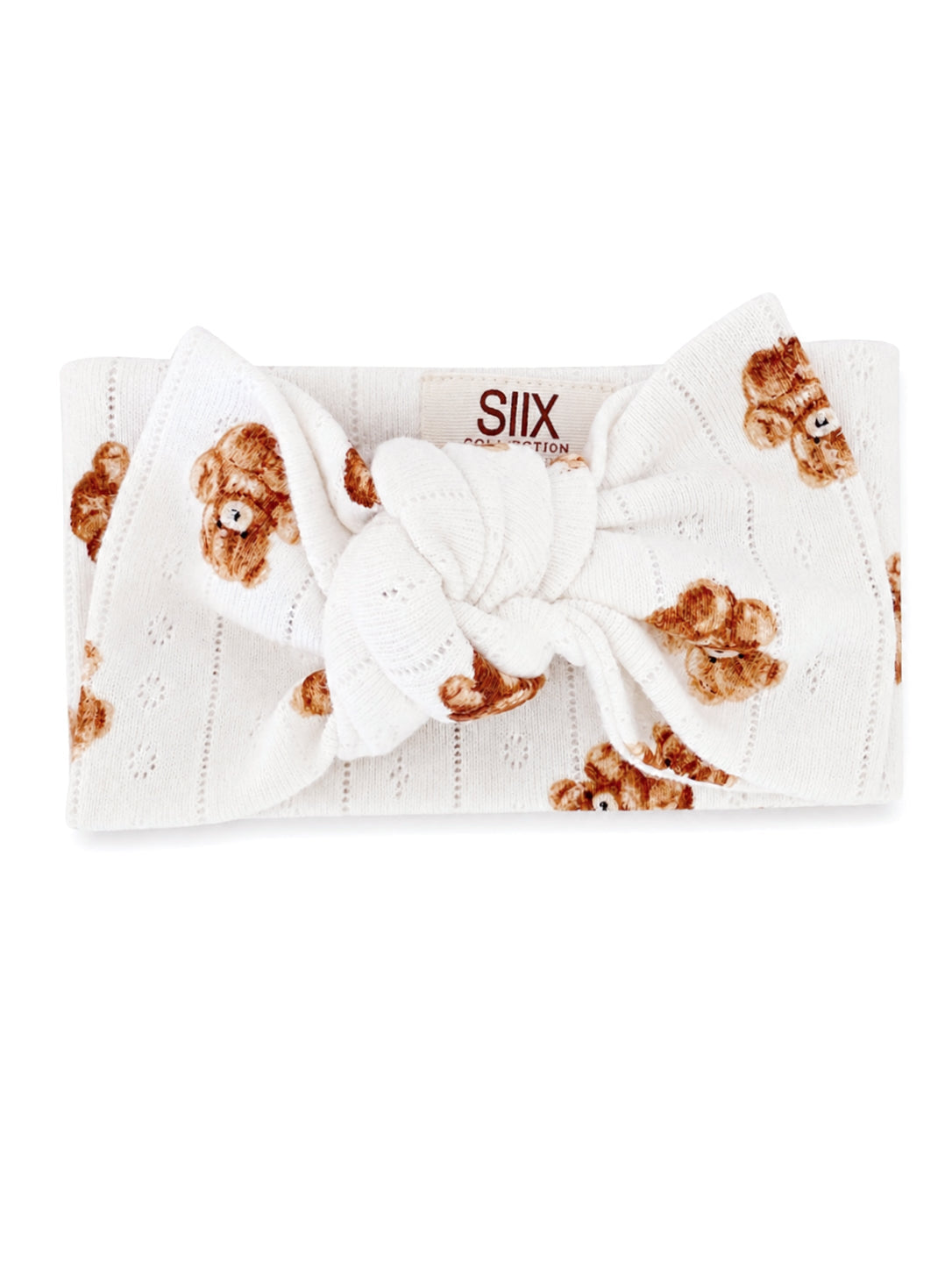 White headband with teddy bear print and a large bow. Suitable for casual wear or baby accessories.