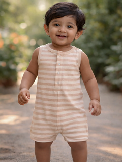 Smiling toddler in a striped romper, standing outdoors with greenery in the background.