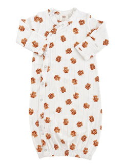 White baby gown with teddy bear print, featuring long sleeves and button closures. Soft and cozy for infants.
