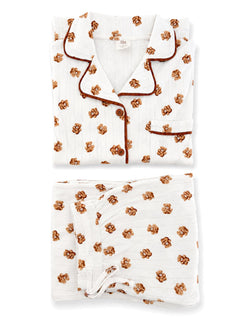 White pajama set featuring brown floral patterns, neatly folded with a top and bottom piece visible.