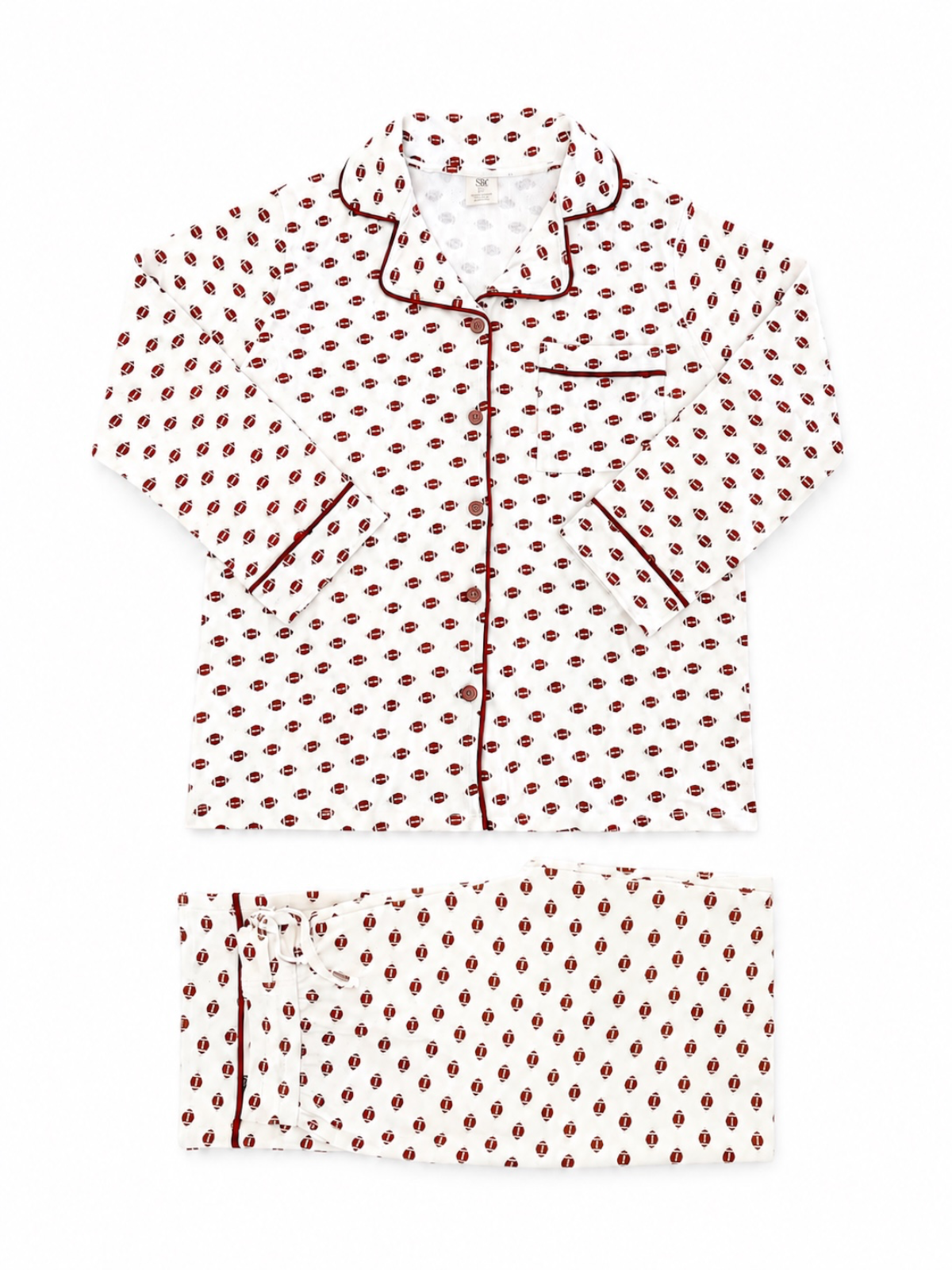White pajama set with red and black patterned design and piped detailing. Includes a button-up shirt and pants.